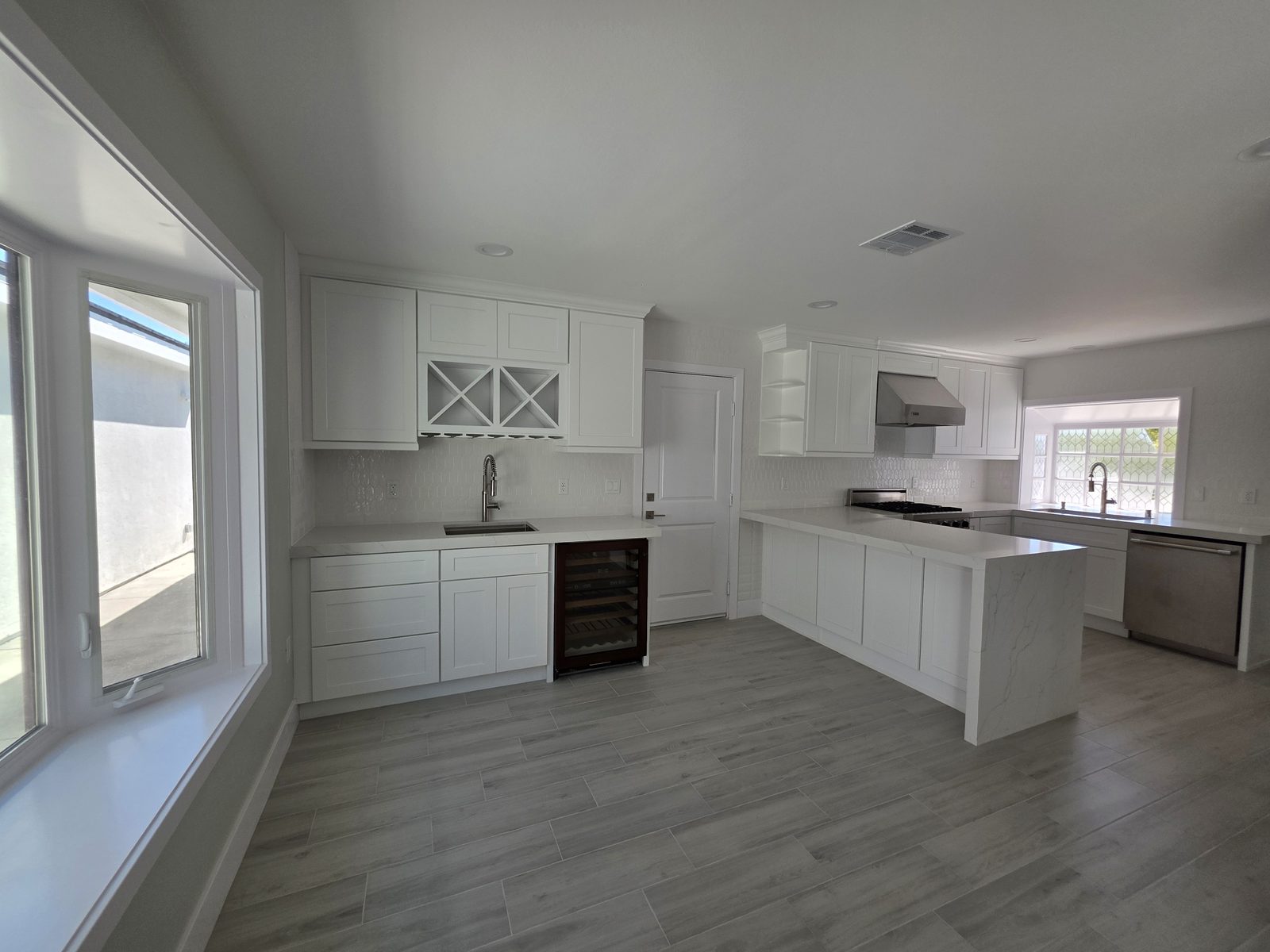 Remodeled kitchen with white shaker cabinets and quartz counters