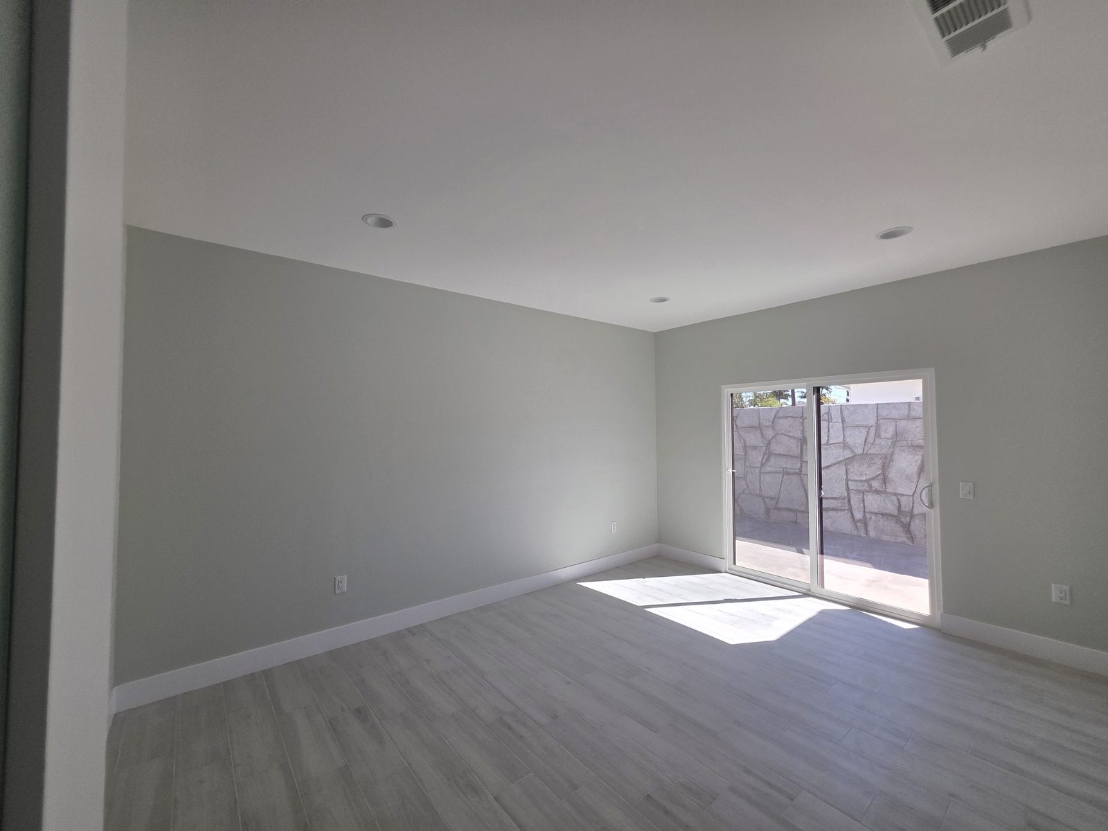 Finished room with sliding glass door to the patio