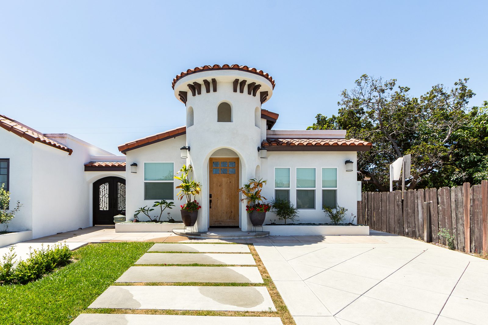 Front of a Spanish-style model home with an entry tower and tile roof in Garden Grove