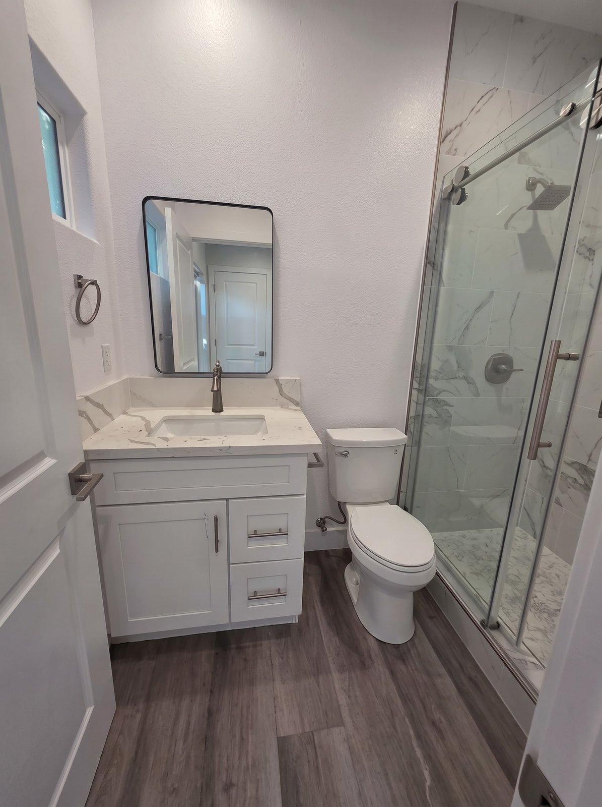 Bathroom with glass shower and white vanity in a new SB9 home
